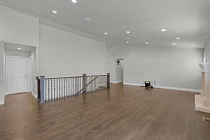 Empty room featuring recessed lighting, wood finished floors, and lofted ceiling