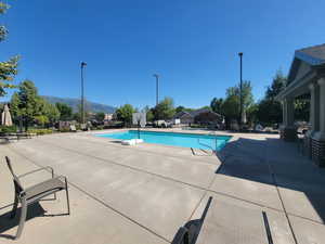 Community pool with a mountain view and a patio area