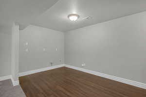 Spare room with baseboards and dark wood finished floors
