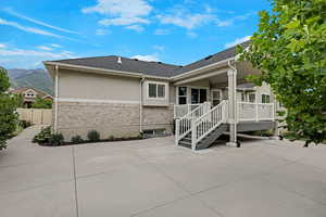 Back of house featuring a patio, stucco siding, a deck with mountain view, and a shingled roof