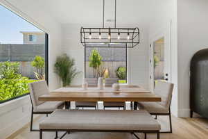 Dining space with light wood-type flooring and a chandelier