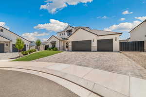 Modern farmhouse with decorative driveway, a garage, stone siding, and a tiled roof