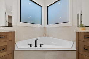 Bathroom with vanity and a bath