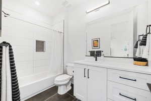 Bathroom featuring vanity, shower / bath combo with shower curtain, and tile patterned flooring