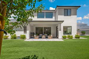 Back of property with stucco siding, an outdoor living space, a patio, and a yard