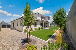 Rear view of house featuring stucco siding, a fenced backyard, and a patio