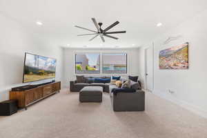 Living area with light carpet, ceiling fan, and recessed lighting