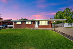 Ranch-style house featuring driveway, an attached carport, entry steps, and brick siding