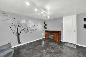 Living area with a textured ceiling and finished concrete flooring
