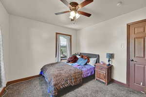 Carpeted bedroom featuring baseboards and a ceiling fan