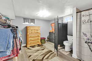 Full bathroom featuring wood finished floors and a textured ceiling