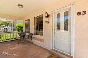 Doorway to property with stucco siding and covered porch