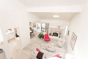 Living room featuring a premium fireplace, vaulted ceiling, and light tile patterned floors