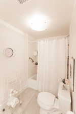 Bathroom featuring toilet and shower / tub combo