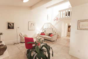 Living room with stairway and a high ceiling