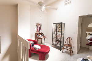 Living area with ceiling fan and baseboards