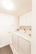 Laundry room featuring cabinet space, independent washer and dryer, and light tile patterned floors