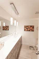 Full bath with double vanity and tile patterned flooring