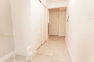 Hallway featuring baseboards and light tile patterned floors