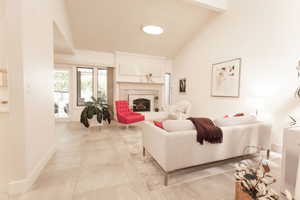 Living area with a high end fireplace and high vaulted ceiling