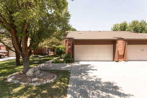 Ranch-style home featuring brick siding, concrete driveway, a shingled roof, and an attached garage