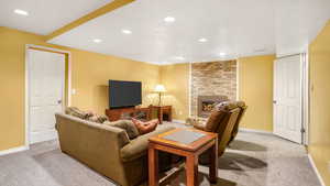 Living room with carpet floors, recessed lighting, and a fireplace