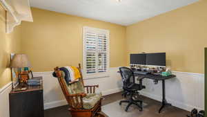 Carpeted office featuring wainscoting
