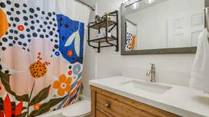Bathroom featuring vanity and shower / tub combo with curtain