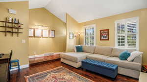 Living room with wood-type flooring and lofted ceiling