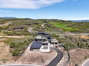 Modern multi-level residence with dark roofing materials and a paved driveway