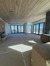 Unfurnished living room featuring a fireplace and wood ceiling