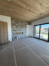 Unfurnished living room featuring wooden ceiling and baseboards