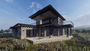 Rear view of house featuring an outdoor hot tub, stone siding, a patio, a balcony, and board and batten siding
