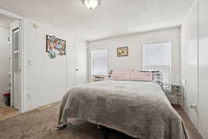Carpeted bedroom with a textured ceiling