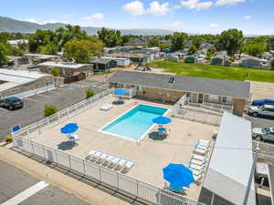 Community pool with a patio area, a mountain view, and a residential view