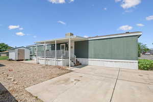Manufactured / mobile home featuring a shed and a porch