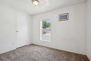 Carpeted spare room featuring a textured ceiling