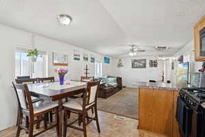 Dining area with ceiling fan, plenty of natural light, and a textured ceiling
