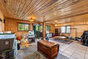 Tiled living area with wooden walls, wood ceiling,