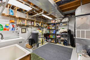 Unfinished basement featuring washer / dryer and a water softener system