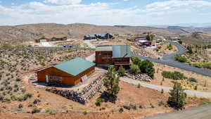 View of subject property with a mountain backdrop large detached garage and over an acre