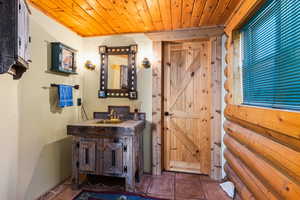 Bathroom with wood ceiling, vanity, and tile patterned floors
