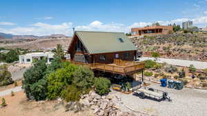 Side view of property featuring log exterior, a deck with mountain view, and a metal roof
