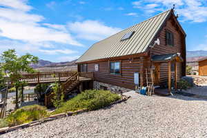 Back of property featuring a standing seam roof, a mountain view, and a metal roof