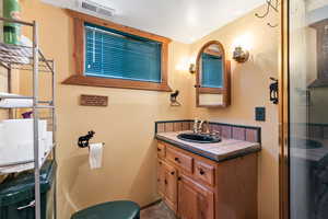 Bathroom with vanity and a shower with shower door