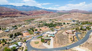 Aerial view of property and surrounding area featuring a mountainous background