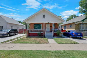 Bungalow-style home with covered porch and brick siding