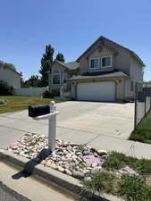 View of front of property with stucco siding, driveway, and a garage