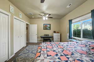 Carpeted bedroom featuring two closets and a ceiling fan