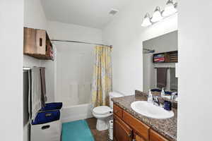 Bathroom with vanity, shower / bath combination with curtain, and tile patterned floors